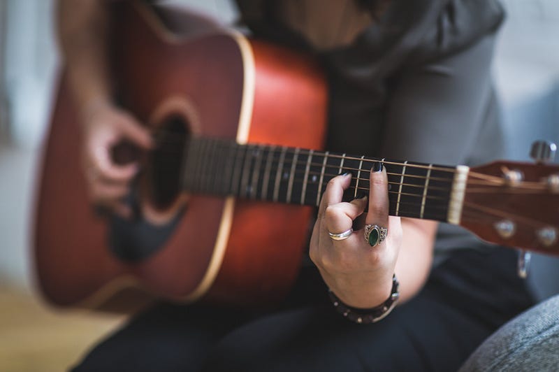 A young girl practicing guitar, embodying the learning process.